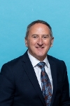 Photograph of man in suit with short dark hair, Thomas Glen Chief Executive